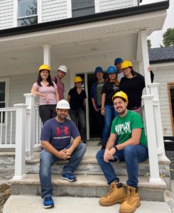 The Behaviorally team poses on the poarch of the house they helped to build with Habitat for Humanity of Greater Newark